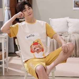 Camiseta de verano y pantalones cortos con estampado de perro que lleva un hombre sentado en una silla en una casa