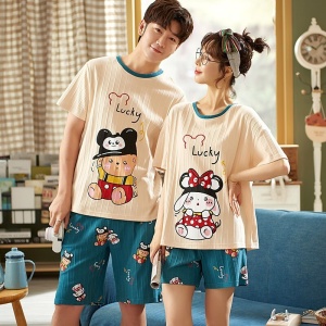 Camiseta de algodón y pantalones cortos con dibujo de dibujos animados que lleva una pareja de moda en una casa