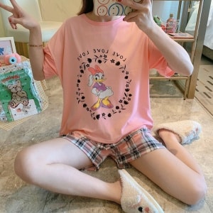 Camiseta de pijama de dos piezas y pantalón corto con estampado de margaritas que lleva una mujer sentada haciéndose una foto