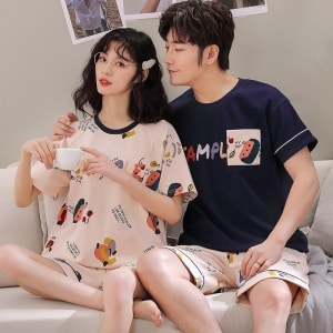 Camiseta de dos piezas de algodón y pantalón corto con dibujo de dibujos animados que lleva una pareja sentada en el sofá de una casa