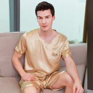 Pijama de satén dorado para hombre sentado en el sofá de una casa