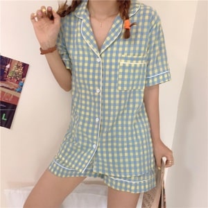Pijama femenino de manga corta a cuadros azul-amarillo que lleva una mujer en una casa