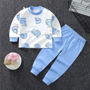Pijama de niño en algodón elefante con pantalón azul liso sobre la alfombra de una casa