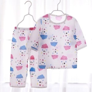 Pijama de verano de algodón blanco con nubes para niños en una percha en una casa
