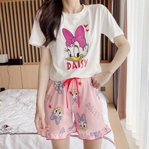 Pijama de verano de algodón rosa y blanco con estampado de margaritas que lleva una mujer en una casa