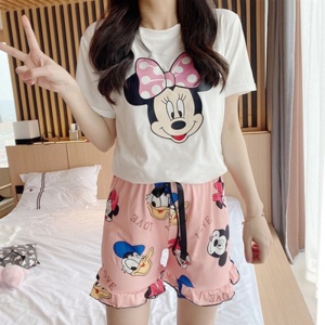 Pijama de verano estampado rosa y blanco de Minnie, Mickey y Donald, llevado por una mujer en una casa