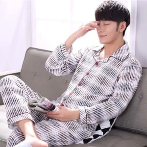 Pijama de algodón a rayas que lleva un hombre sentado en una silla en una casa