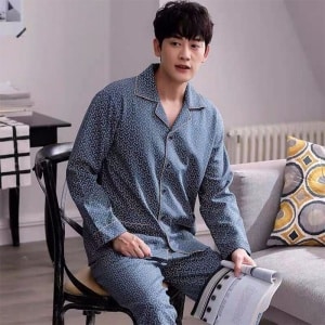 Pijama de algodón a la moda llevado por un hombre sentado en una silla en una casa
