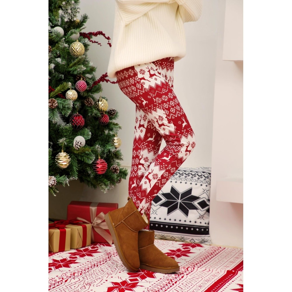 Leggings para mujer con estampado navideño en blanco y rojo que lleva una mujer en una casa