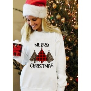 Jersey de manga larga para mujer con diseño de árbol de Navidad y "Feliz Navidad" llevado por una mujer delante de un árbol de Navidad en una casa