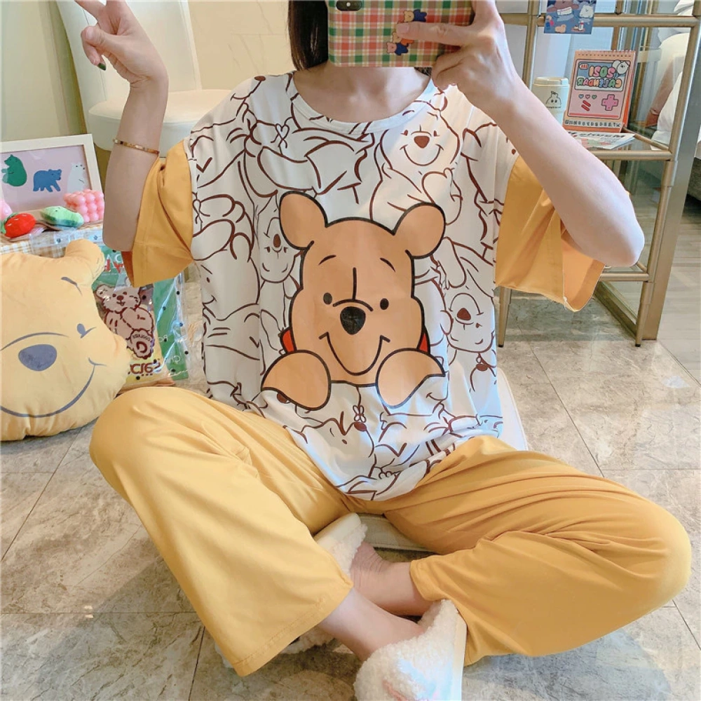 Pijama amarillo y blanco de manga corta de Winnie the Pooh que lleva una mujer sentada haciéndose una foto delante de un espejo