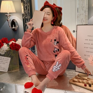 Pijama femenino rosa de Mickey llevado por una mujer con diadema roja en una casa de moda