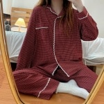 Pijama de invierno a cuadros retro de mujer que lleva una mujer haciéndose una foto delante de un espejo