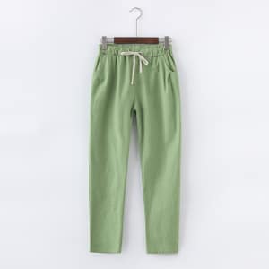 Pantalón verde claro de algodón y lino colgado en una percha