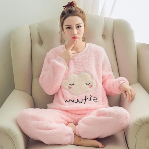 Cálido pijama rosa nublado con una mujer vestida con el pijama en el sofá