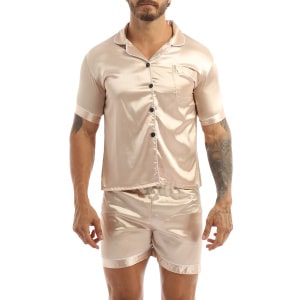 Pijama de satén beige llevado por un hombre con un tatuaje en el brazo izquierdo, el pijama consiste en un pantalón corto y una camisa con botones en la parte delantera