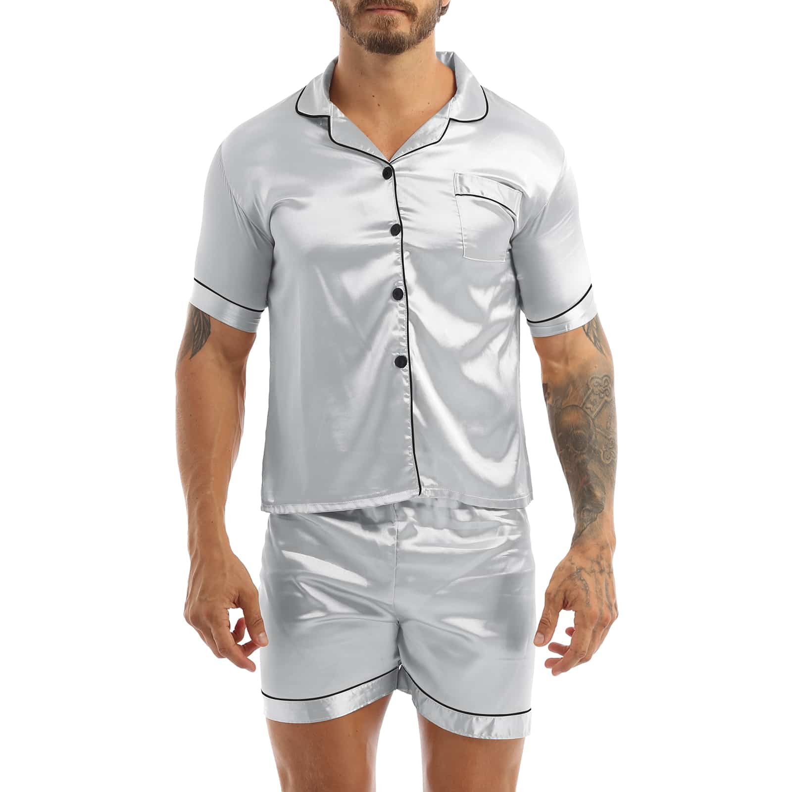 Pijama de satén gris llevado por un hombre con un tatuaje en el brazo izquierdo, el pijama consiste en unos pantalones cortos y una camisa con botones en la parte delantera