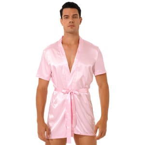 hombre moreno de pie con pijama kimono de satén rosa atado a la cintura con un cinturón