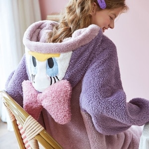 Mono Disney morado y rosa con una mujer sonriente en pijama