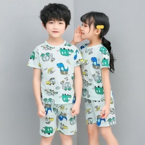 Pijama verde de dos piezas con estampado de dibujos animados para niños con dos niños vestidos con el pijama y un fondo gris
