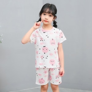 Pijama blanco de dos piezas con estampado de dibujos animados para niñas con una niña vistiendo el pijama