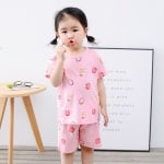 Pijama rosa de dos piezas de fresa para niñas con una simpática niña vistiendo el pijama