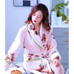 Pijama femenino de forro polar con estampado floral que lleva una mujer sentada en la cama de una casa