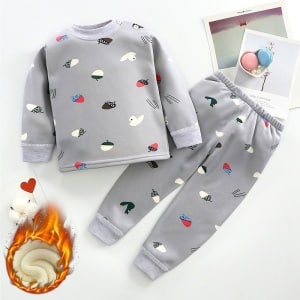 Pijama de niño de algodón gris estampado con patos sobre fondo blanco con objetos a los lados
