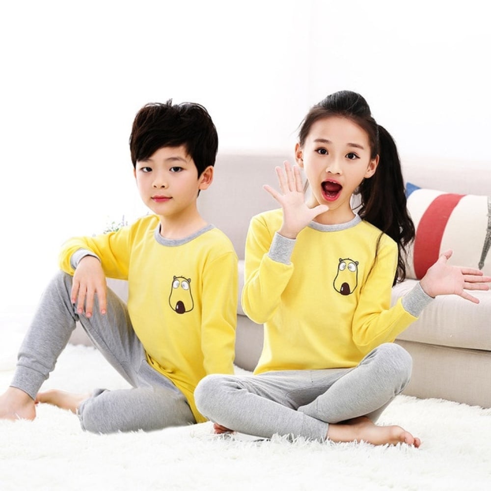 Pijama de primavera con jersey amarillo y pantalón gris para niños con dos niños vistiendo el pijama