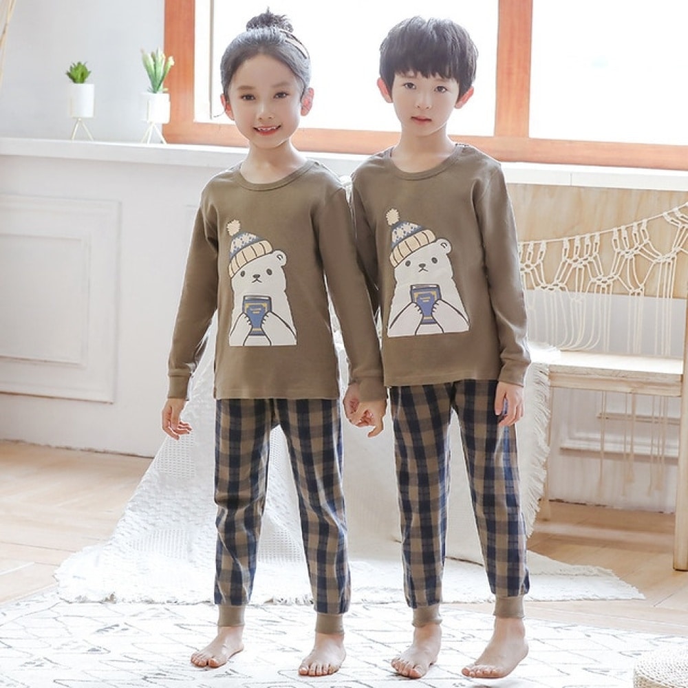 Pijama de primavera con jersey beige y pantalones a cuadros para niños con dos niños que llevan el pijama es un fondo una habitación