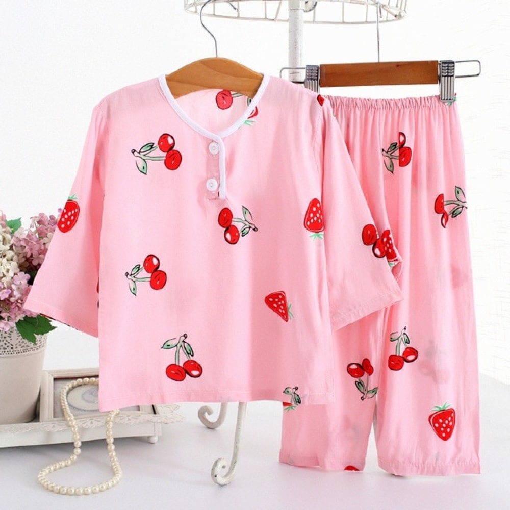 Pijama de algodón de fresas y cerezas rosas con medias mangas sobre un cinturón en una casa