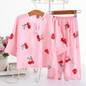 Pijama de algodón de fresas y cerezas rosas con medias mangas sobre un cinturón en una casa