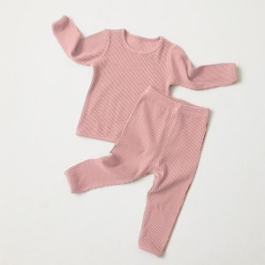 Pijama de dos piezas de algodón rosa para niña con fondo blanco