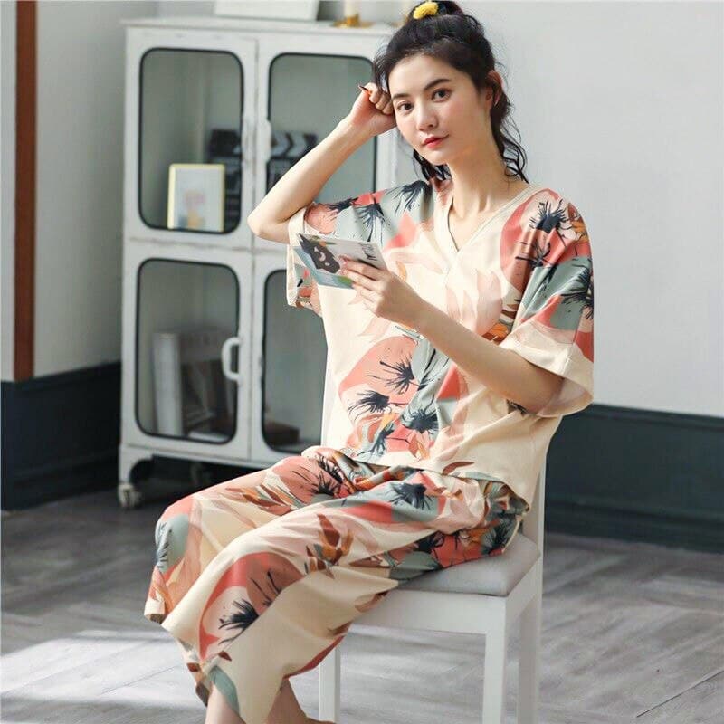 Pijama de verano de dos piezas con cuello en V y estampado floral que lleva una mujer sentada en una silla en una casa