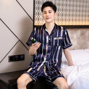 Pijama de lujo de manga corta para hombre con cuello doblado con un hombre vistiendo el pijama con un fondo de dormitorio