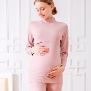 Un pijama premamá de dos piezas de algodón rosa lo lleva una mujer rubia embarazada