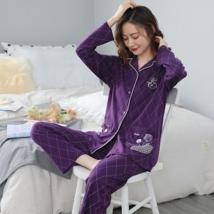 Pijama púrpura de dos piezas para mujer con motivos geométricos una mujer llevando el pijama púrpura, con un fondo un dormitorio