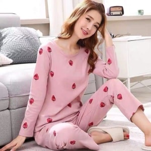 Pijama rosa de fresa de manga larga para mujer llevado por una mujer en una casa