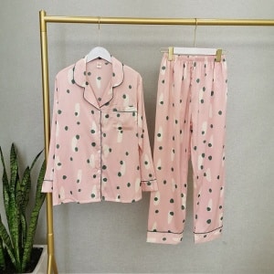 Pijama de dos piezas rosa de manga larga para mujer en una percha en una casa