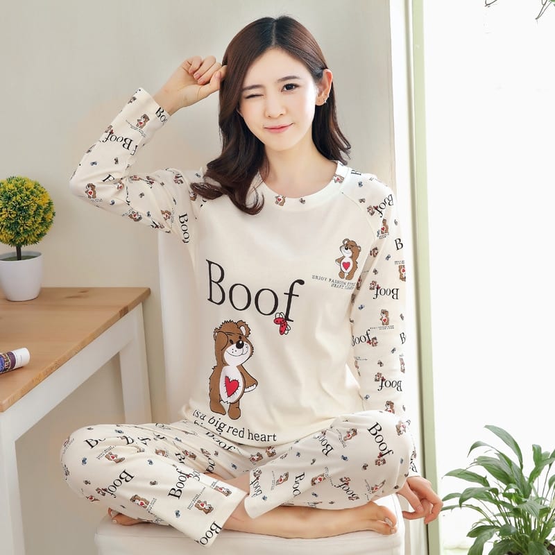 Pijama de mujer blanco de otoño con estampado Boof con fondo de mesa con una planta y una mujer con el pijama puesto