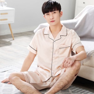 Pijama de satén de manga corta para hombre con cuello doblado y un hombre con el pijama puesto en el sofá