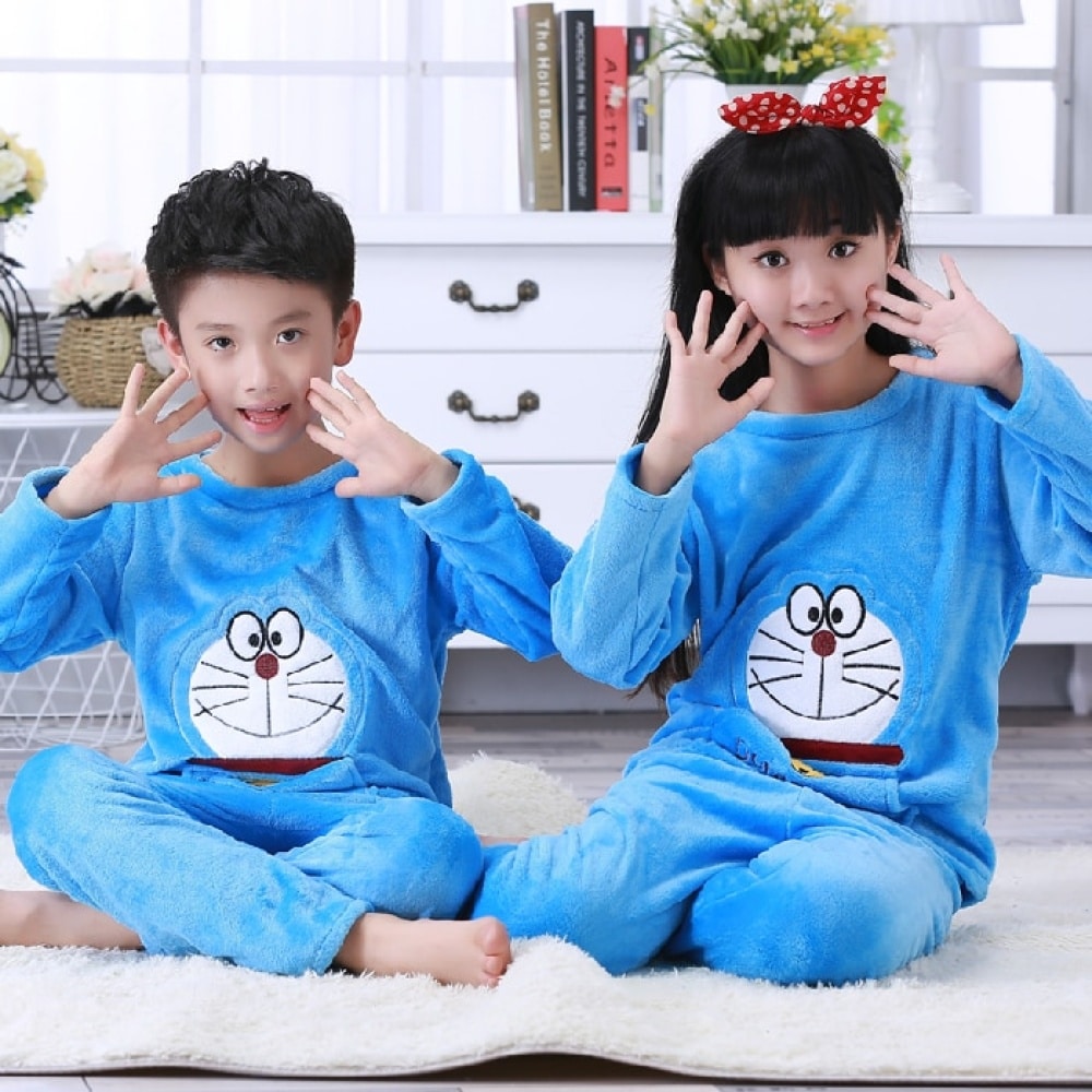 Pijama de franela azul de manga larga con estampado de Doraemon para niño sentado en la alfombra de una casa