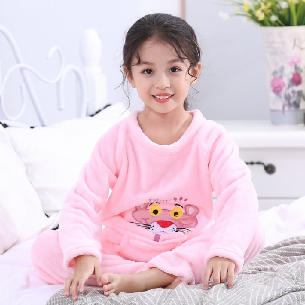 Pijama de franela con estampado de la Pantera Rosa para niña puesto en la cama de una casa