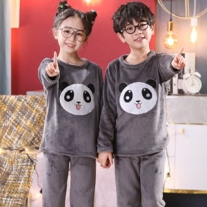 Pijama panda de manga larga de dos piezas que llevan un niño y una niña en una casa