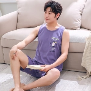 Pijama de verano sin mangas de algodón morado para hombre llevado por un hombre sentado en una alfombra delante de una silla en una casa