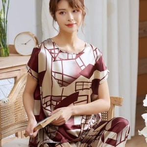 Lujoso pijama femenino de dos piezas y manga corta que lleva una mujer sentada en una silla en una casa