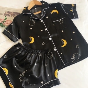 Pijama de verano de satén negro noche estrellada con fondo blanco y periódico