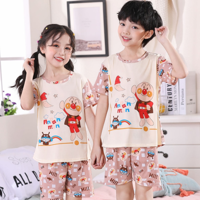 Pijama de verano con motivos de dibujos animados para niños que llevan un niño y una niña en el interior de una casa con un marco colgado en la pared