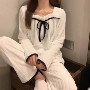 Pijama femenino de forro polar blanco que lleva una mujer en una casa