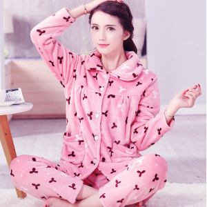 Pijama femenino de forro polar grueso y cálido que lleva una mujer sentada en la alfombra de una casa